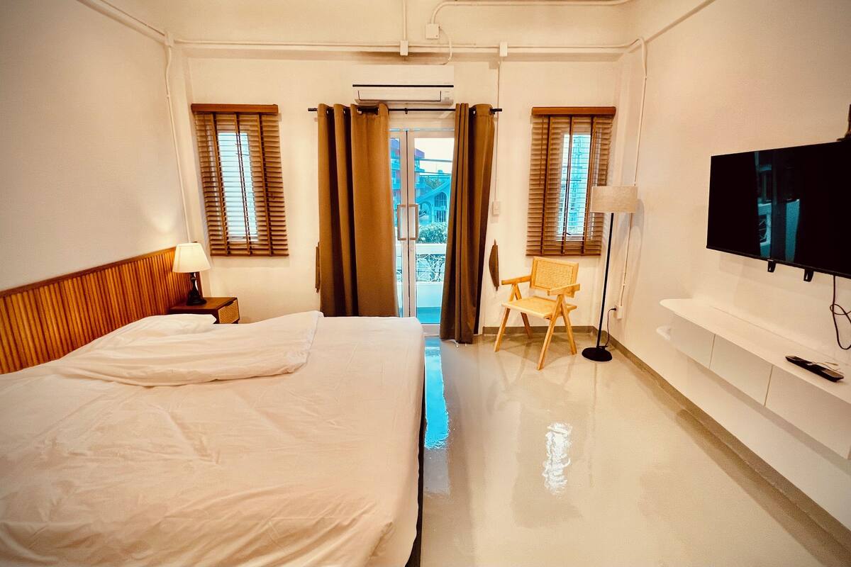 Une chambre d’hôtel équipée d’un lit, d’une chaise, d’un téléviseur et d’un appareil de climatisation.
