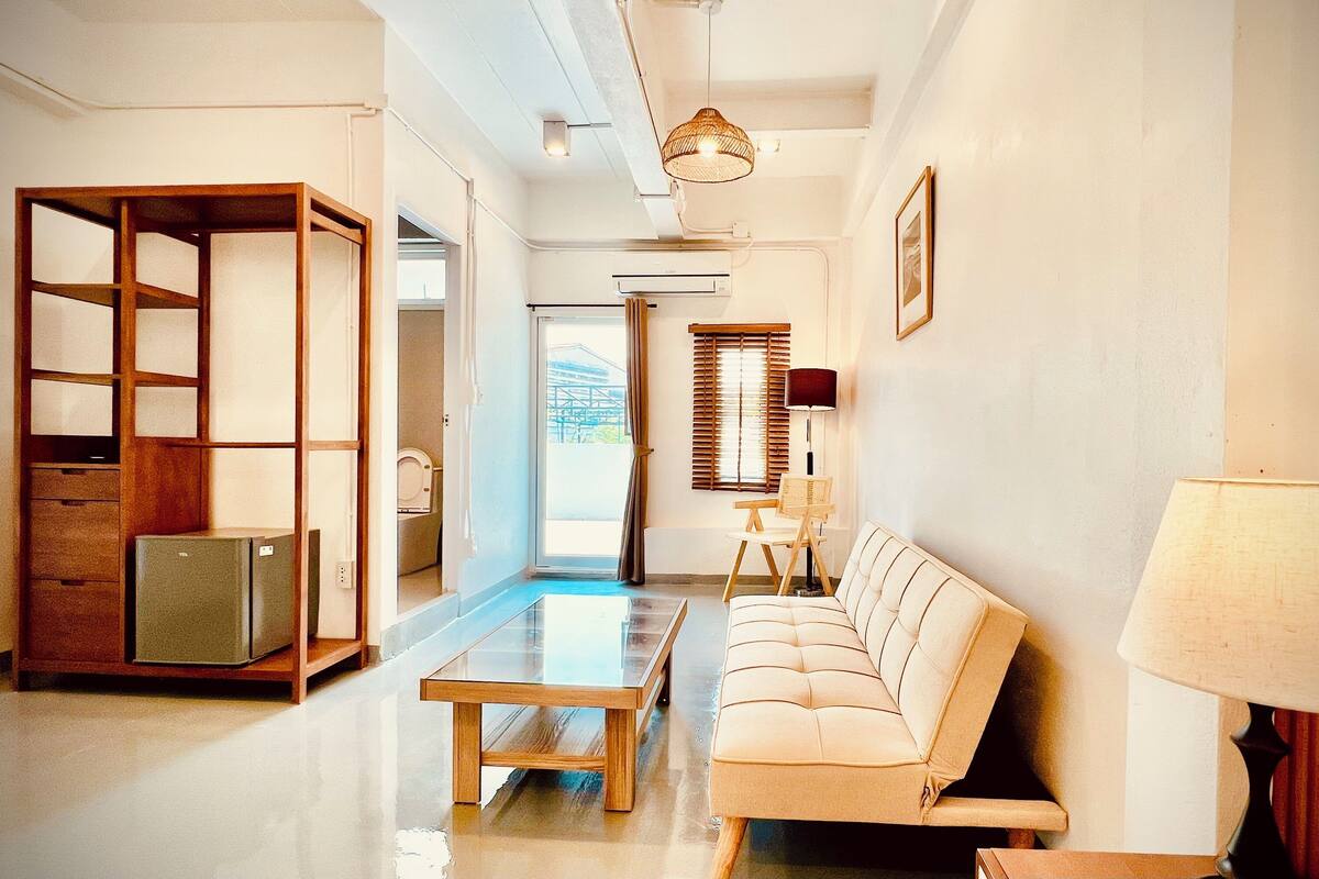 Un salon moderne avec un canapé, une table basse, une lampe et un meuble en bois.