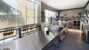 A modern kitchen with a long counter, bar seating, and large windows. - Blanca8 - 17 - Apartment with a kitchen (Canggu)
