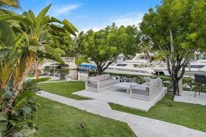 A landscaped outdoor area with a seating area, a pathway, and a body of water. - The Frankie's Suite @ Yacht Club, 5 minute walk from Grace Bay Beach (Providenciales)
