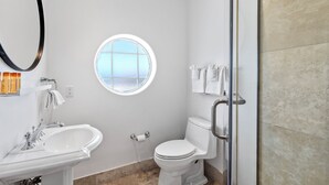 Une salle de bain avec des toilettes, un lavabo et une douche.