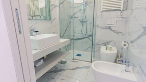 Ein modernes Badezimmer mit einer Duschkabine, einem weißen Waschbecken und einer Badewanne.