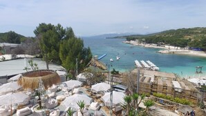 A coastal resort with outdoor seating, a beach, and boats in the water. - EMAR Beachfront Hotel Ksamil (Ksamil)