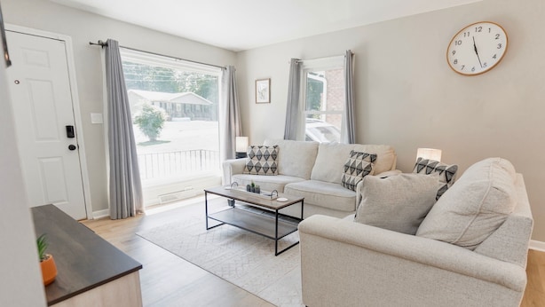 A living room with a sofa, coffee table, and curtains. - Cozy Pet Friendly 3BR - Fenced Yard - 1Mi HPU & DwnTwn - Furniture Market (High Point)
