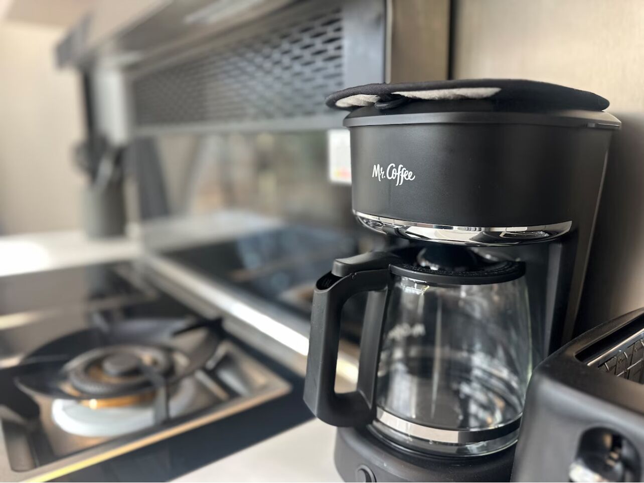 Eine Mr. Coffee Kaffeemaschine mit Glasbehälter auf einer Küchenarbeitsplatte.
