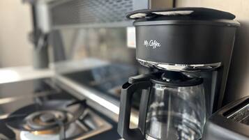 Eine Mr. Coffee Kaffeemaschine mit Glasbehälter auf einer Küchenarbeitsplatte.