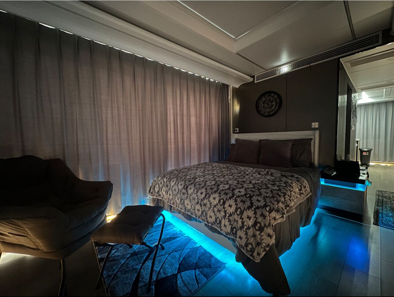Une chambre à coucher moderne avec un grand lit, un canapé et une petite table.