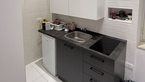 A compact kitchen with a sink, a dishwasher, and a countertop with various items. - Apartment in the heart of Naples Corso Umberto I Kitchen Wi-Fi climate center port (Napoli)