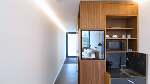 Una cocina moderna con armarios de madera, un microondas y una cafetera.