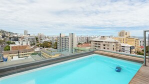 A rooftop pool with a city view, surrounded by buildings and a clear sky. - Central Sea Point Studio | Rooftop Pool (Cape Town)