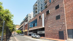 A street view of a building with a parking garage labeled "GREENWICH SQUARE PARKING".