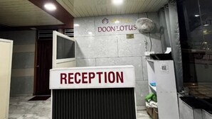 A reception area with a sign reading "RECEPTION" and a wall with "HOTEL DOON LOTUS" signage. - Hotel Doon Lotus (Dehradun)