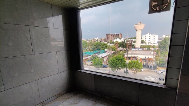 A room with a large window, tiled floor, and a visible clock. - Hotel Doon Lotus (Dehradun)
