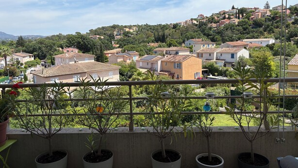 A balcony with potted plants and a view of a residential area with houses and greenery. - 20 mns from beaches and center of St Raphaël.2 50m2 type with nice terrace. (Saint-Raphaël)