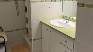 A bathroom with a shower, a sink with a mirror, and cabinets. - 20 mns from beaches and center of St Raphaël.2 50m2 type with nice terrace. (Saint-Raphaël)