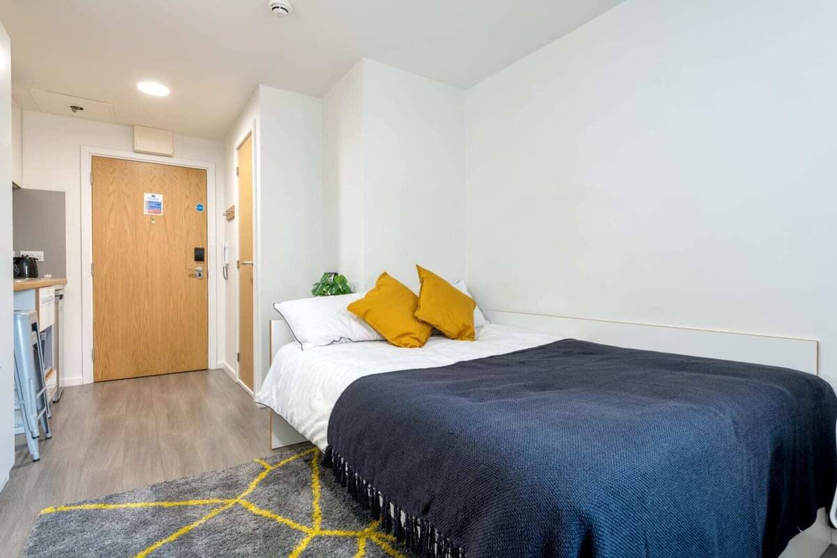Une chambre d’hôtel avec un lit, un bureau et une porte.