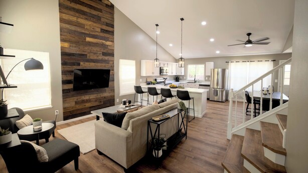 Una sala de estar moderna con chimenea, un comedor y una cocina.