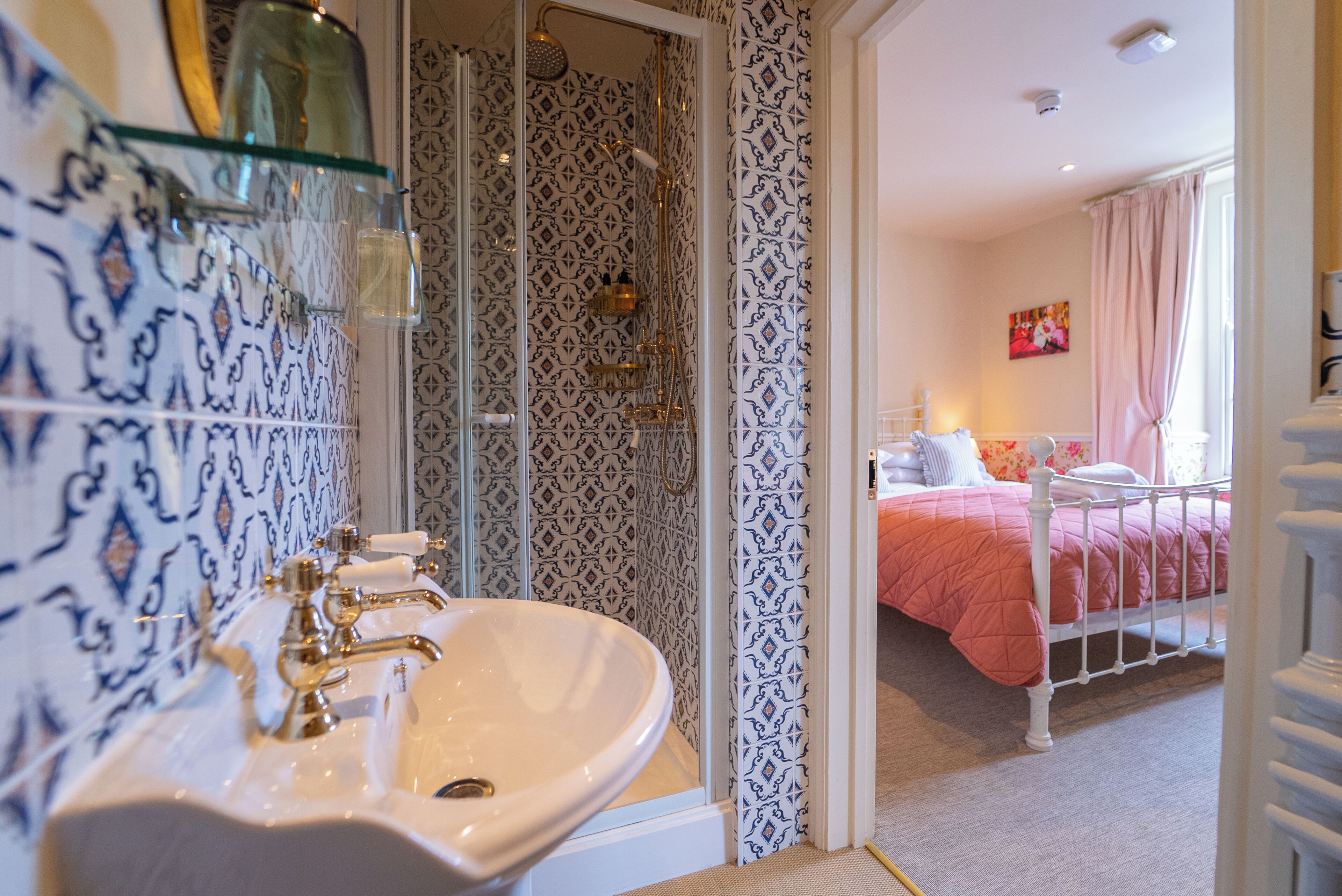Ein Badezimmer mit weißem Waschbecken, Dusche und Wandmustern.
