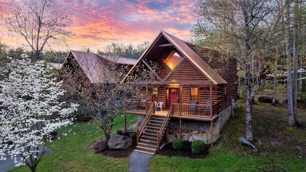 A log cabin with a porch, a staircase, and a view of the surrounding forest. - Resort Pool Fitness Room Hot Tub Jacuzzi (Gatlinburg)