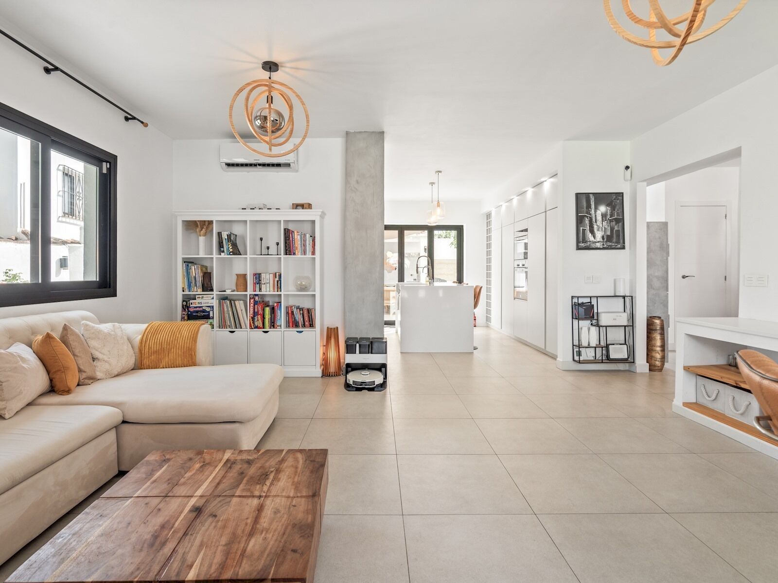 A modern living room with a sofa, coffee table, and a bookshelf.