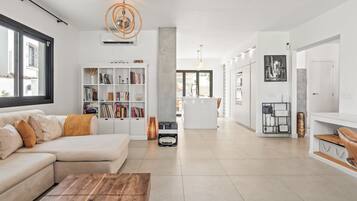 A modern living room with a sofa, coffee table, and a bookshelf.