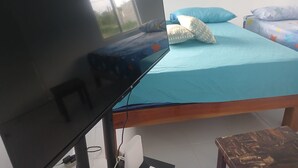 A bedroom with a bed, a TV, and a desk. - Blue Song Villa (Rio Bueno)