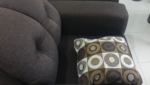 A dark-colored sofa with a tufted backrest and a patterned cushion. - Blue Song Villa (Rio Bueno)