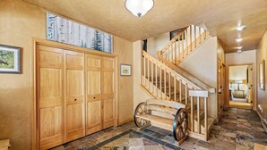 A spacious hallway with a wooden staircase, a large wooden wardrobe, and a unique wooden cart. - 4bd Townhome, Mtn Views, Pool & Hot Tub 1079 (Steamboat Springs)