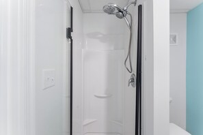 Een douche, handdoeken, zeep, toiletpapier