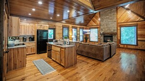 A spacious kitchen with wooden cabinets, a central island, and a built-in oven. - River Song- 1BR-Timber Creek Trails-Creekside (broken bow)