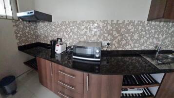 Una cucina accessoriata con forno a microonde, tostapane e lavandino.