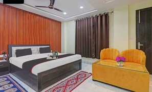 Une chambre à coucher avec un lit, un canapé, un ventilateur de plafond et des rideaux.