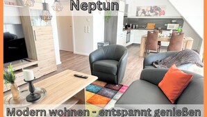 Un salon moderne avec un téléviseur, un canapé et une table basse.