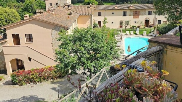 A villa with a swimming pool, surrounded by lush greenery and traditional architecture.