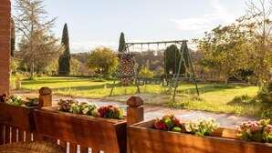 A garden with wooden benches and a swing set. - Villa Maria Pia - Roman Elegance Immersed in the Green (Aranova)