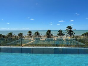 Una piscina al aire libre, sombrillas, sillones reclinables de piscina