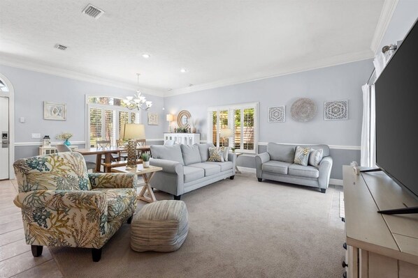 A spacious living room with two sofas, a coffee table, and a television.