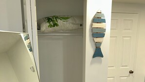 A room with a white closet, a wooden floor, and a door with a brass doorknob.