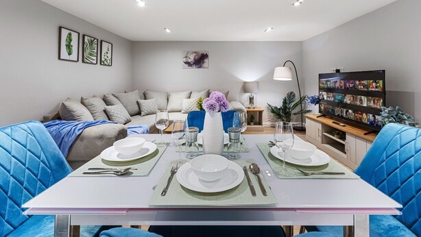 Una sala de estar moderna con comedor dispuesto para cuatro personas.