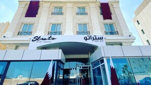 A hotel with a classical facade, multiple balconies, and a clear entrance. - Premium Strato Hotel (Doha)