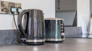 A kitchen with a kettle and a toaster on a countertop, connected to a power outlet. - Single ensuite room nr Falkirk with self-check-in (Grangemouth)