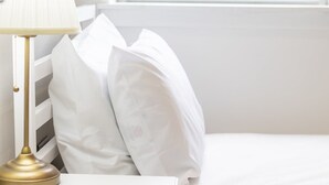 A white bed with pillows, a white nightstand, and a gold lamp. - Single ensuite room nr Falkirk with self-check-in (Grangemouth)