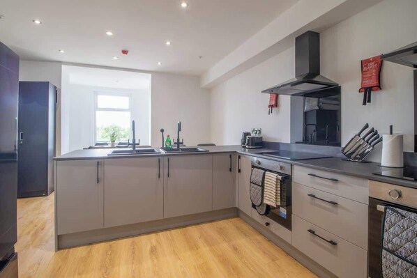 A modern kitchen with a large island, built-in appliances, and a view to the outside. - Double Ensuite Room + Shared Kitchen + Fast Wi-Fi (Grangemouth)