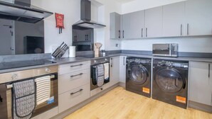 A compact kitchen with a microwave, oven, and washing machine. - Double Ensuite Room + Shared Kitchen + Fast Wi-Fi (Grangemouth)