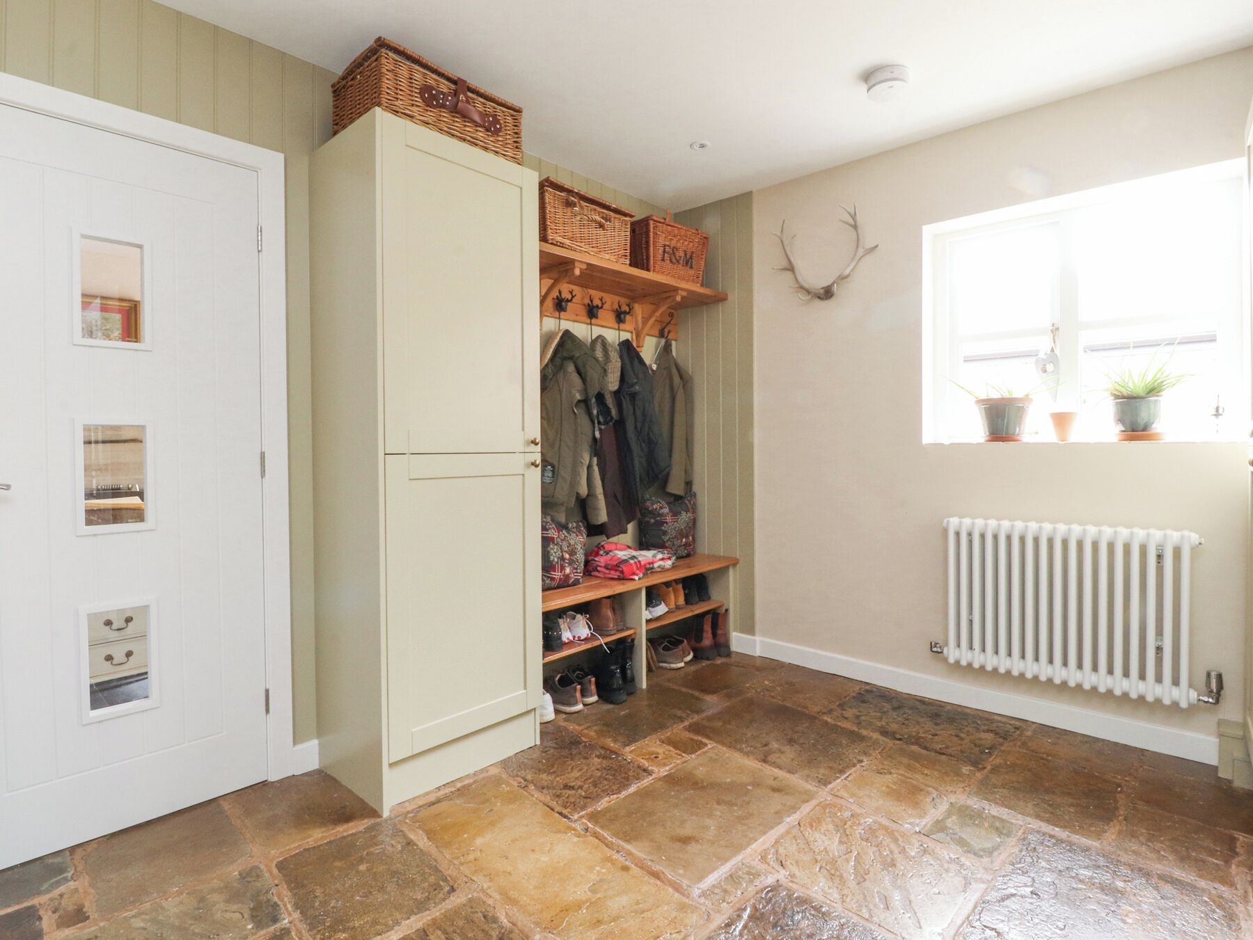 A hallway with a wardrobe, a coat rack, and a radiator.