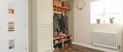 A hallway with a wardrobe, a coat rack, and a radiator.