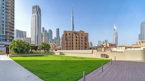 A rooftop with a grassy area, modern buildings, and a clear sky. - Vogue | Downtown near Dubai Mall | Burj Khalifa (Dubai)