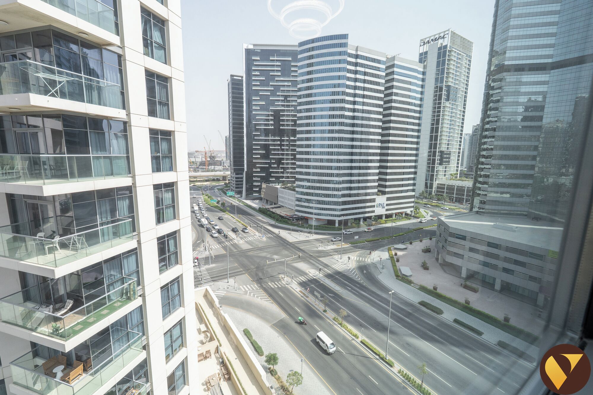 A modern high-rise building with a curved facade, multiple floors, and a glass exterior.