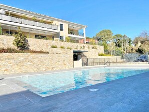 A modern building with a swimming pool, stone walls, and a balcony. - Beautiful apartment for 5 with swimming pool (Saint-Raphaël)