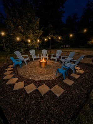 A circular seating arrangement with a central fire feature, surrounded by steps and outdoor lighting. - Brand new 2BR, 1.5BA-close to amenities yet feels secluded. 2 story, AC, wifi! (Bridgton)